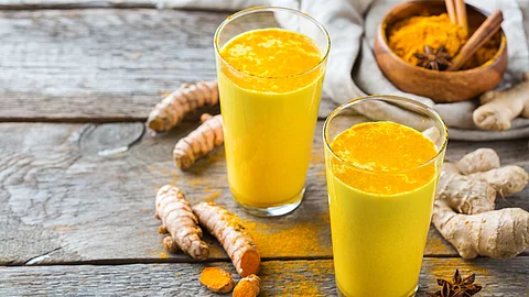 2 Gläser Kurkumamilch auf Holzuntergrund