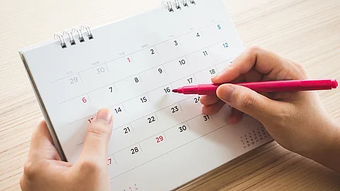 Eine Hand schreibt etwas in einen Terminkalender 
