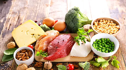 protein food sources on wood background Proteinhaltige Nahrungsmittel: Fleisch, Fisch, Käse, Nüsse, Mandeln, Erbsen
