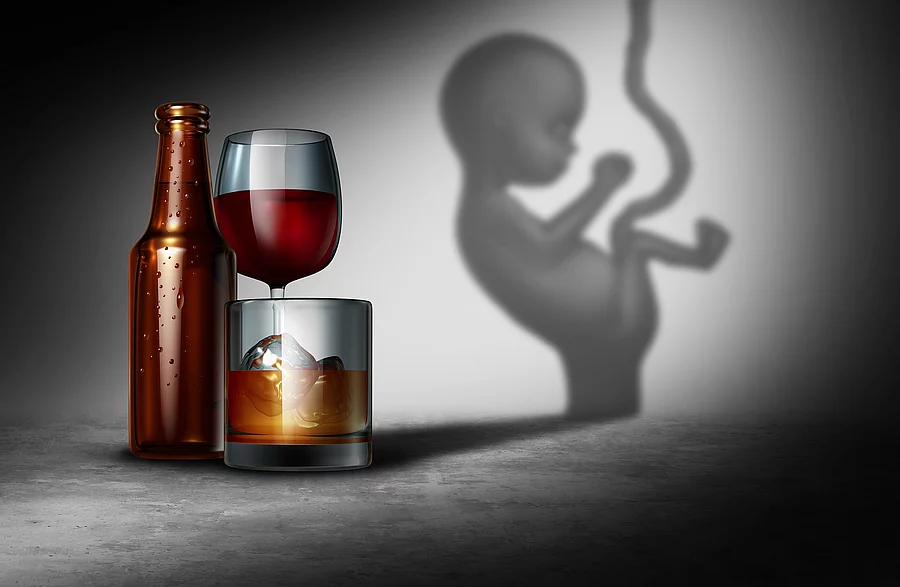 Illustration: Fötus neben Bierflasche und Rotweinglas vor grauem Hintergrund