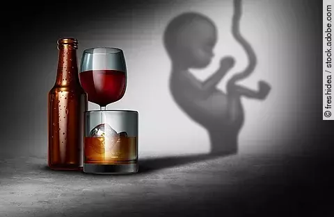 Illustration: Fötus neben Bierflasche und Rotweinglas vor grauem Hintergrund
