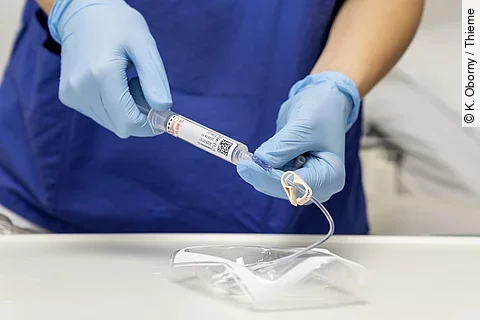 eine Ärztin oder Krankenschwester spritzt etwas in ein Portsystem