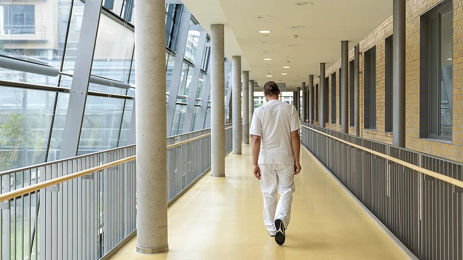 Krankenpfleger von hinten auf einem Krankenhausflur Krankenpfleger von hinten auf einem Krankenhausflur