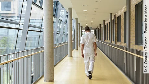 Krankenpfleger von hinten auf einem Krankenhausflur