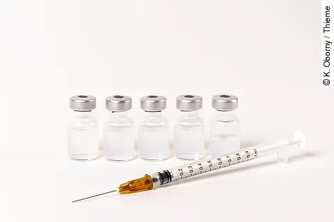 5 Ampullen mit Impfserum und 1 Spritze vor weißem Hintergrund