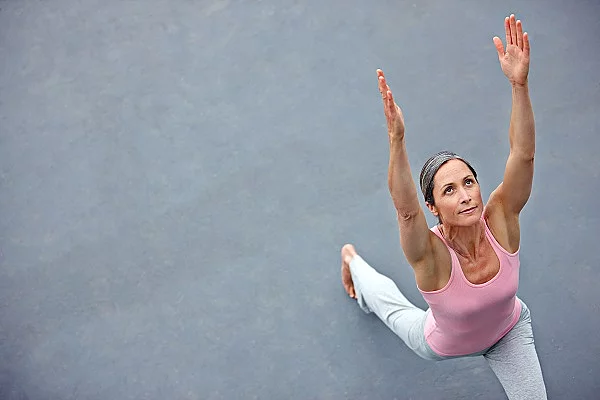 Frau macht draußen Yoga, Krieger 1