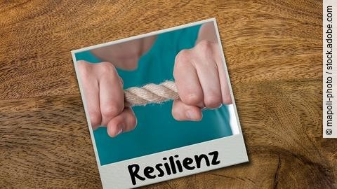 Bild ist mit dem Wort Resilienz beschriftet. Abgebildet ist eine Person, die ein Seil zwischen den Händen spannt.