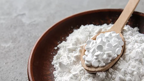 Stevia Pillen in einer Holzschale und auf einem Holzlöffel.