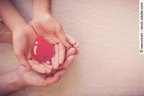 4 Hände halten einen stilisierten Blutstropfen