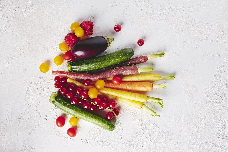 Wurzelgemüse und Beeren auf weißer Tischdecke