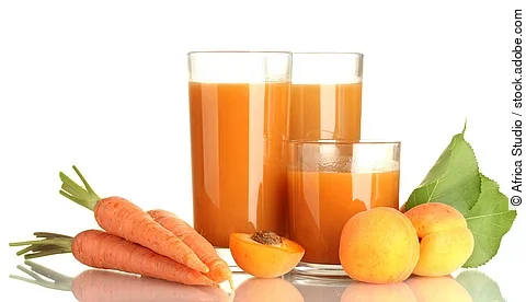 2 Gläser mit Möhrensaft, arrangiert mit frischen Möhren und Aprikosen