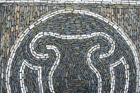 Symbolbild: Uterus in weißen Steinen gelegt auf grauen Pflastersteinen