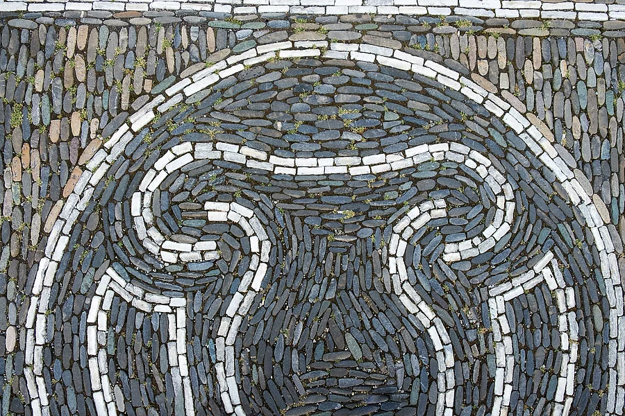 Symbolbild: Uterus in weißen Steinen gelegt auf grauen Pflastersteinen