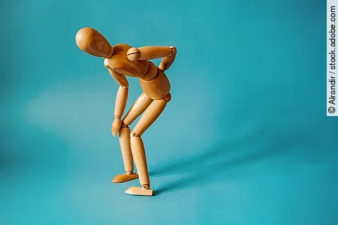 Concept of back pain. A wooden figure depicts a pain in the back
