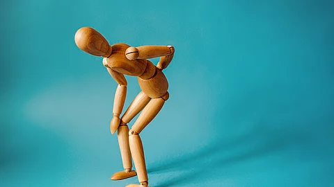 Concept of back pain. A wooden figure depicts a pain in the back