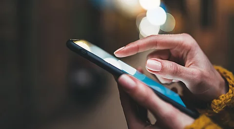 Frauenhände tippen auf Smartphone