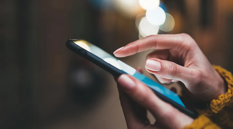 Frauenhände tippen auf Smartphone