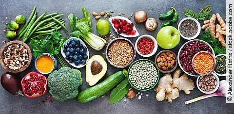 Mediterrane Gemüse, Obst, Beeren, Nüsse auf grauem Hintergrund