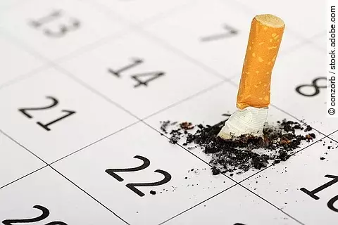 Ausgedrückte Zigarette auf einem Kalender. 