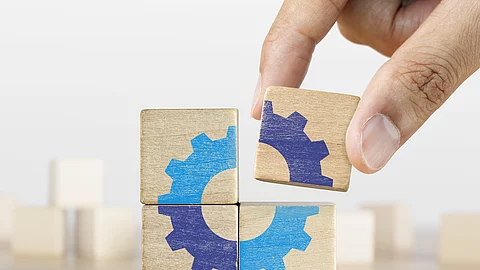 Ein letztes Puzzlestück in Form von einem Holzklotz wird zusammengefügt.
