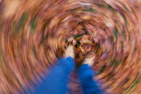 verschwommen Aufnahme aus POV Blickwinkel auf Füße im Herbstlaub