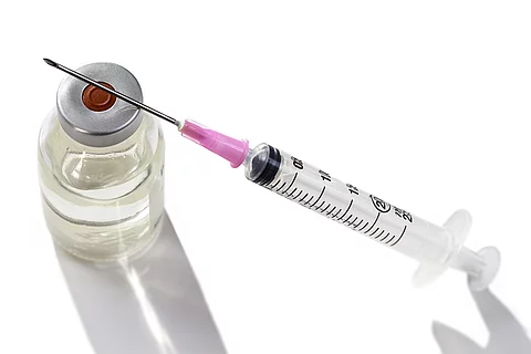 Eine Ampulle mit Impfstoff und eine Spritze