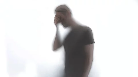 Silhouette eines Mannes, der sich an die Stirn fasst.