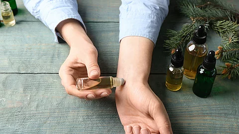 Frau trägt Aromaöl auf dem Handgelenk auf.