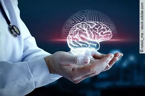 Arzt hält 3D-Illustration eines Gehirns in den Händen.