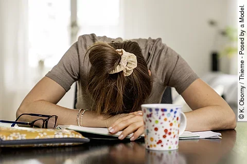 Frau hat den Kopf auf dem Schreibtisch