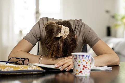 Frau hat den Kopf auf dem Schreibtisch
