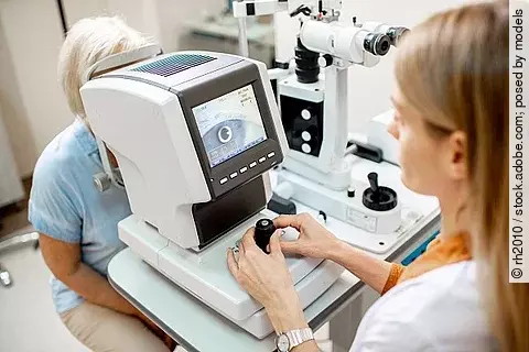 Augenärztin kontrolliert das Auge einer Patientin durch ein Messgerät.