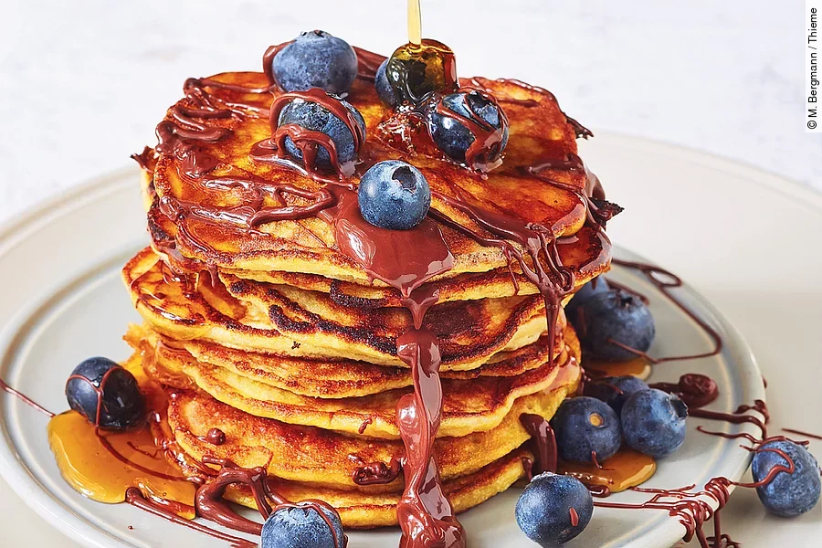 Bananen-Pancakes mit Schokolade, Ahornsirup und Heidelbeeren