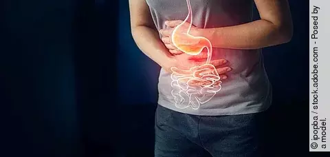 Frau hält sich Bauch mit schmerzen