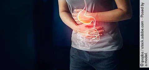 Frau hält sich Bauch mit schmerzen