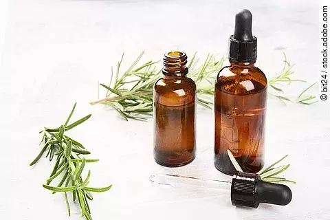 Aromatherapie Symbolbild: Rosmarinzweige und Braunfläschchen