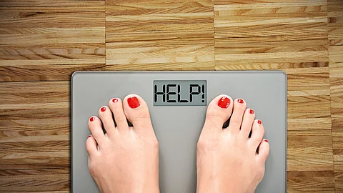Time to start a diet with women’s feet on a scale, saying HELP Frauenfüße auf einer Waage, mit der Anzeige HELP