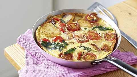 Gemüseomelette in einer Pfanne auf einem Holztisch