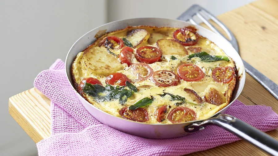 Gemüseomelette in einer Pfanne auf einem Holztisch