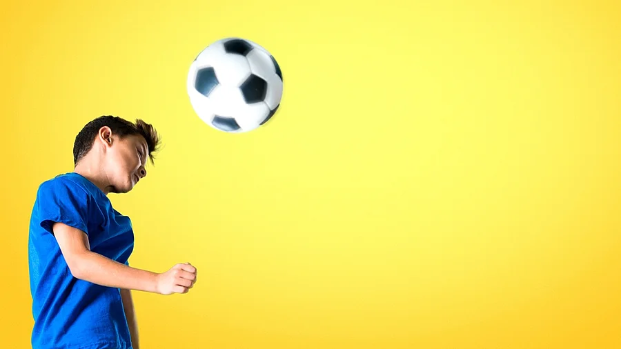 Junge spielt einen Kopfball Junge spielt einen Kopfball