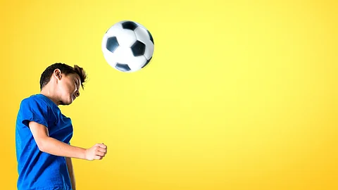 Junge spielt einen Kopfball