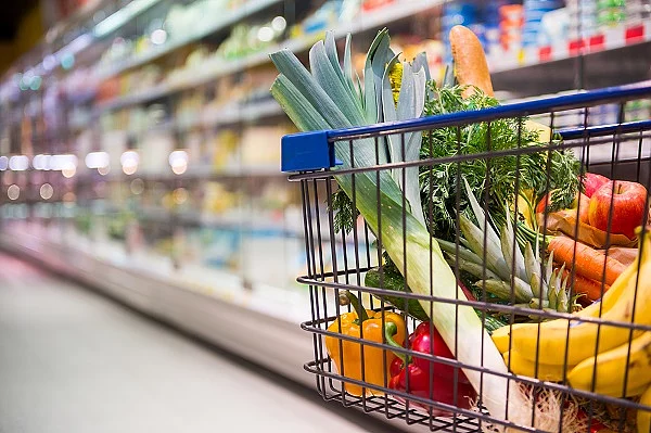 Einkaufswagen voller Einkäufe in einem Supermarkt.