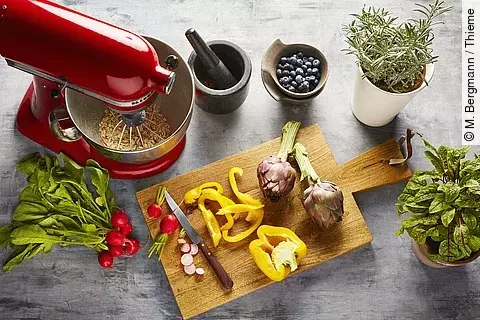 frische Kräuter, ein Brett mit geschnittenem Gemüse, Haferflocken, Heidelbeeren, 1 Bund Radieschen