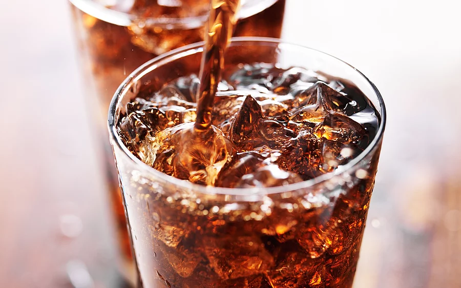 ein Glas Cola mit Eiswürfeln und Strohhalm ein Glas Cola mit Eiswürfeln und Strohhalm