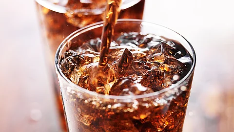 ein Glas Cola mit Eiswürfeln und Strohhalm