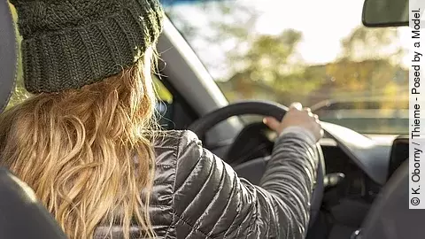 Junge Frau sitzt am Lenkrad eines Autos