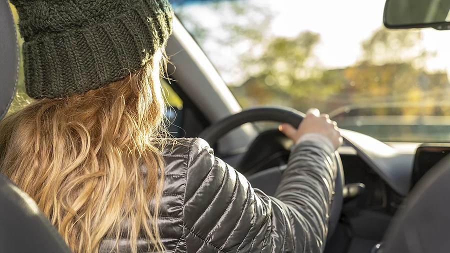 Junge Frau sitzt am Lenkrad eines Autos