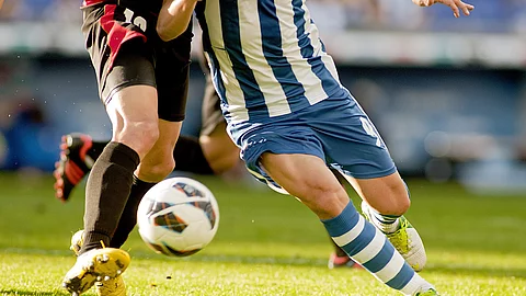 2 Fußballspieler kämpfen um den Ball auf dem Rasen