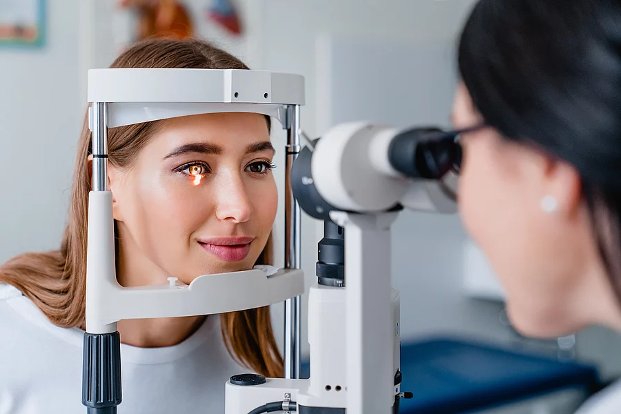 Eye doctor with female patient during an examination in modern c Augenarzt untersucht Frau