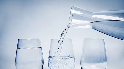 3 Gläser nebeneinander, Karaffe mit Wasser